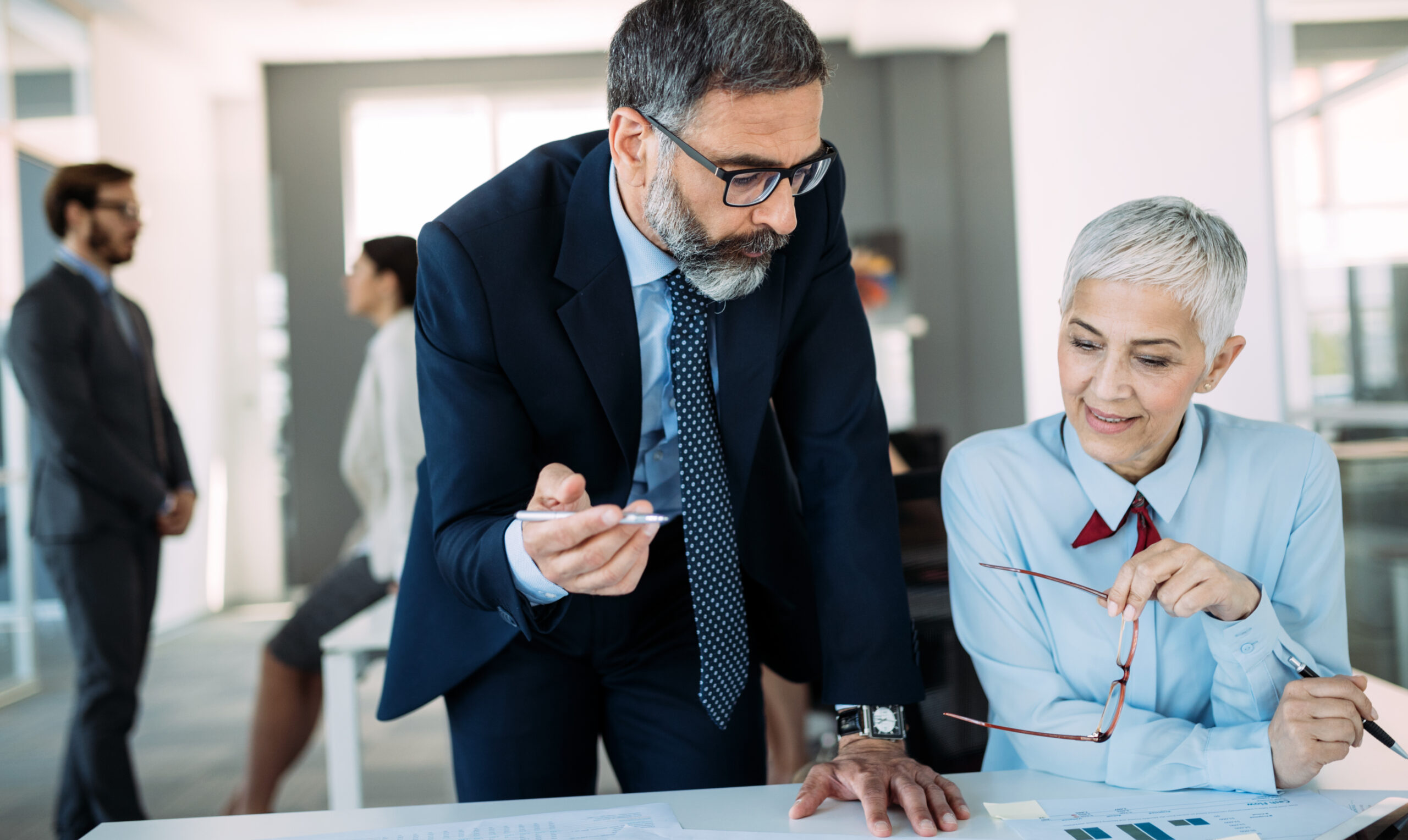 Happy Mature Businessman And Businesswoman Planning In Office