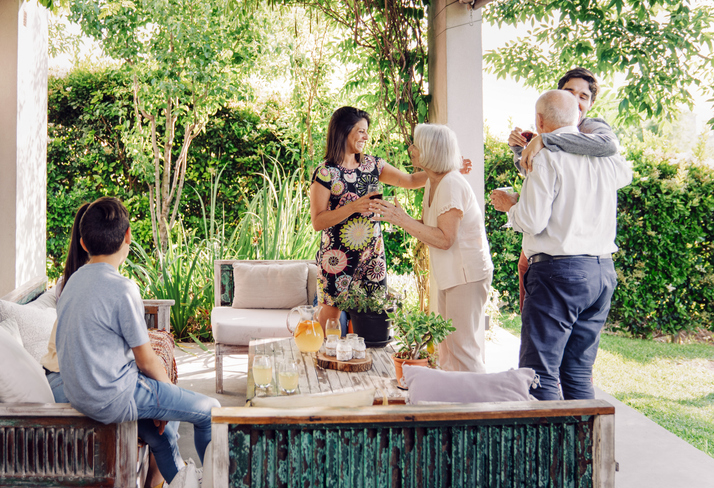 Happy Family Greeting Each Other In Patio During Weekend Party